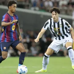 Jugadores de fútbol en acción, uno con camiseta azulgrana y otro a rayas blancas y negras, creando un triangular en el campo.