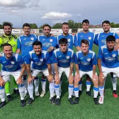 El equipo de fútbol Atlético Cervantino posa en el campo, con camisetas azules y blancas.