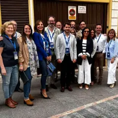 Grupo de personas sonriendo frente a un edificio. cf almaguer.