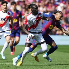 Jugadores del Rayo Vallecano y Barcelona en acción. Un jugador del Rayo, con el dorsal 6, lucha por el balón.