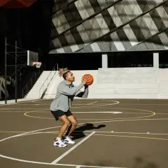 Hombre concentrado en un tiro libre de baloncesto en una cancha exterior.