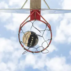 Un balón de baloncesto a punto de entrar en la canasta. La altura reglamentaria de a cuantos metros está la canasta de baloncesto del suelo es de 3.05 metros.