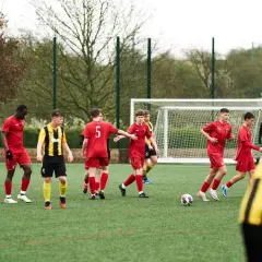 Jugadores de fútbol realizan ejercicios de coordinación en un campo sintético.