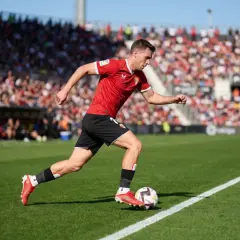 Futbolista en acción, parte de la pirámide del fútbol español, con público en las gradas.