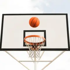 Balón de baloncesto naranja en el aire, a punto de entrar en la canasta. ¡Un tiro perfecto!