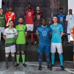 Jugadores de la liga de Canadá posan con sus nuevas equipaciones de fútbol, mostrando una variedad de colores y patrocinadores.
