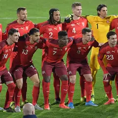 El equipo de fútbol suizo posa en el campo. Los jugadores lucen sus uniformes rojos, listos para el partido.