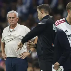 Entrenador jugador con gesto de desaprobación. El entrenador, con su mano, señala hacia abajo, mientras un jugador del Real Madrid observa.