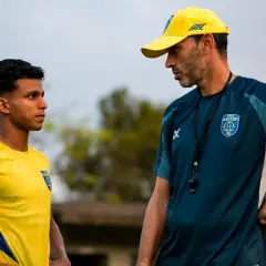 Entrenador habla con jugador joven en la liga india futbol.