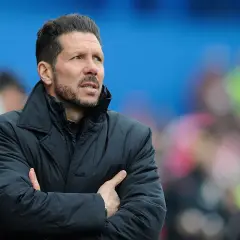 Diego Pablo Simeone, con los brazos cruzados, mira atentamente el partido con una chaqueta oscura.