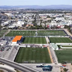 Vista aérea de la ciudad deportiva Valencia, con múltiples campos de fútbol verdes y edificios.