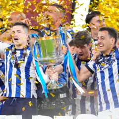 Jugadores celebran con la copa tras ganar la final Copa del Rey. Confeti dorado cae sobre ellos.