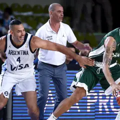 Jugadores de baloncesto argentinos en acción. El número 4 de Argentina intenta robar el balón a un oponente.