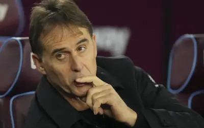 Entrenador de Qatar, con la mano en la barbilla, pensativo, sentado en un banco.