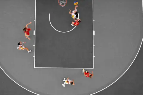 Jugadoras en acción durante un partido de baloncesto 3×3. Una lanza al aro, otra defiende.