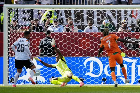 Portero se lanza para atajar un gol en partido de fútbol entre Alemania y Costa Rica.
