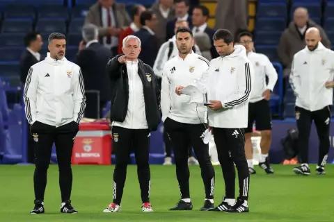 El coach de fútbol, José Mourinho, señala algo en el campo mientras su equipo observa.