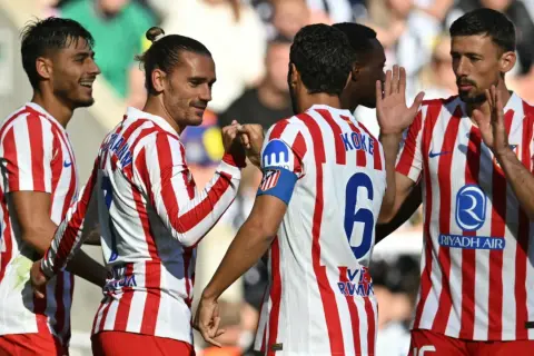 Jugadores del Atlético de Madrid celebran un gol. En primer plano, Griezmann choca el puño con Koke, ambos con la camiseta rojiblanca.
