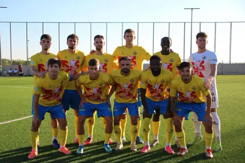 Equipo de fútbol posando en el campo, con camisetas amarillas y pantalones azules. El logo de "Santa Catalina" es visible.