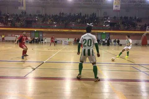 Jugadores de fútbol sala en un partido. Uno con el dorsal 20, R. Bermusell, y otro con el 14. El tacon Villarrobledo resuena en la cancha.