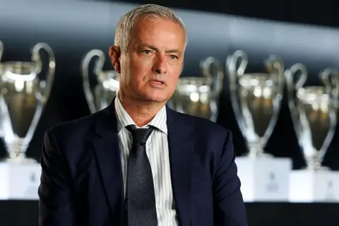 José Mourinho, el legendario **entrenador Madrid**, posa con trofeos de la Champions League.
