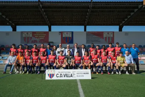 El equipo de fútbol C.D. Villa posa para una foto grupal en el campo.