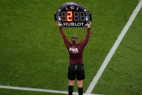 Árbitro muestra el tablero con el número 8, indicando un cambio o el tiempo de descanso en el futbol.