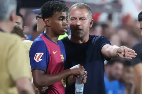Entrenador habla con joven jugador del Barça. La tensión del partido contra el Inter se siente en el aire.