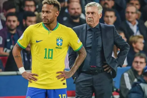Neymar, con la camiseta de Brasil, y Carlo Ancelotti, observan el partido. La esperanza de la **copa** está en sus manos.
