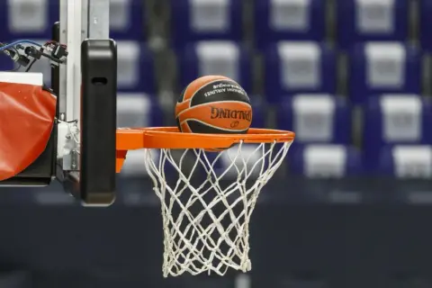 Balón de baloncesto a punto de entrar en la canasta. El juego tiene dos partes principales: ataque y defensa.