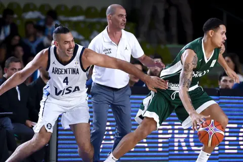 Jugadores de baloncesto argentinos en acción. El número 4 de Argentina intenta robar el balón a un oponente.