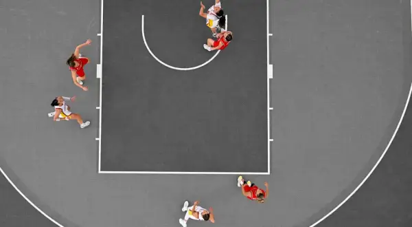 Jugadoras en acción durante un partido de baloncesto 3×3. Una lanza al aro, otra defiende.