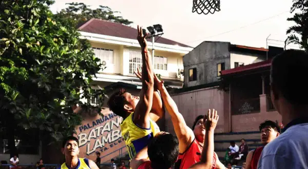 Jugadores de baloncesto compiten por el balón tras un tiro fallido, demostrando que es un rebote en baloncesto.
