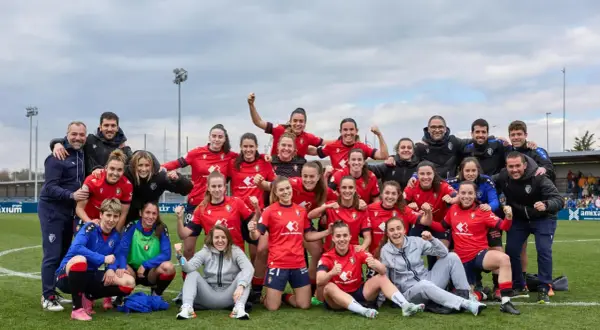 Equipo de fútbol femenino celebra su clasificación. Jugadoras sonrientes y con puños en alto, junto a su cuerpo técnico.