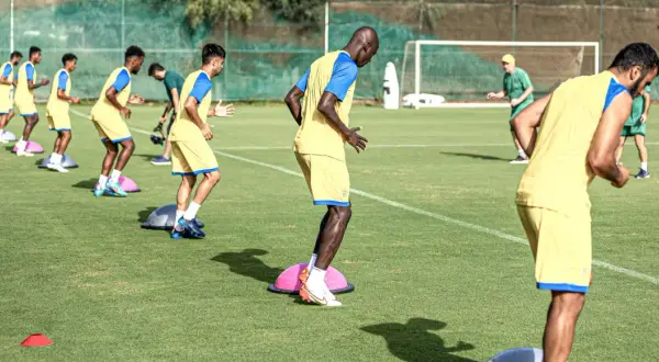 Jugadores de fútbol en pretemporada entrenan equilibrio sobre bosus.