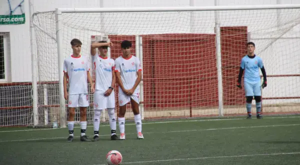 Jugadores del cd cabecense esperan un tiro libre frente a la portería. El portero se prepara.