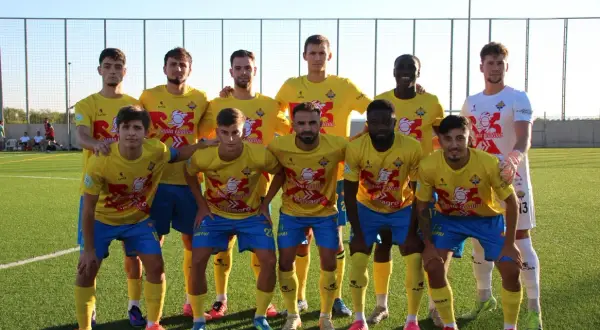 Equipo de fútbol posando en el campo, con camisetas amarillas y pantalones azules. El logo de "Santa Catalina" es visible.