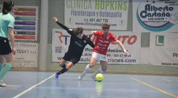 Jugadores de fútbol sala compiten por el balón. Uno viste de negro, el otro de rojo, ambos con calcetines altos. El partido se desarrolla en una cancha interior con publicidad de "cd bargas" y otros patrocinadores.