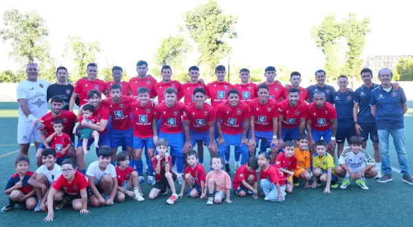 Equipo de fútbol posa para una foto grupal, con adultos y niños. Los **ffcm resultados preferente** son evidentes en la unidad del equipo.