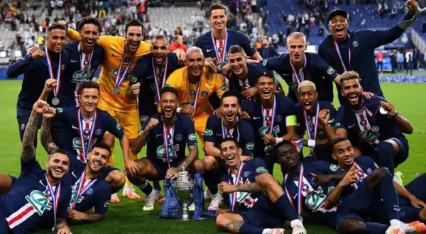 Jugadores del PSG celebran con trofeo y medallas tras ganar la liga francesa de fútbol.