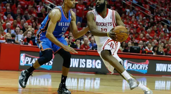 Jugadores de baloncesto en acción. James Harden con el balón, defendido por un jugador de Oklahoma City. Esto es que es el baloncesto.