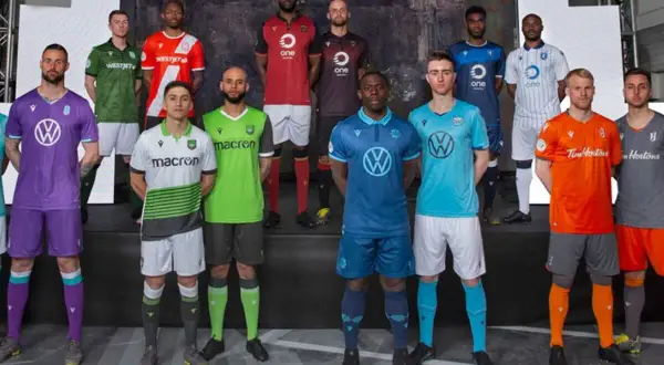 Jugadores de la liga de Canadá posan con sus nuevas equipaciones de fútbol, mostrando una variedad de colores y patrocinadores.
