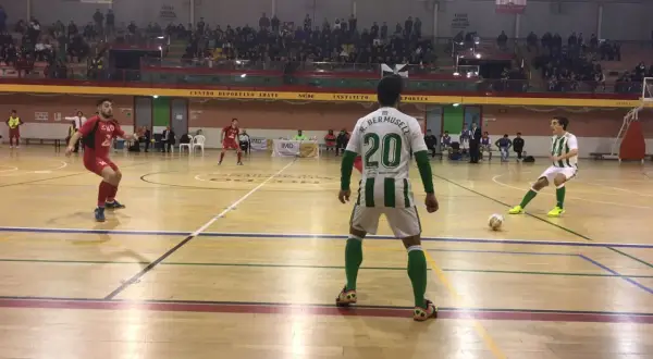 Jugadores de fútbol sala en un partido. Uno con el dorsal 20, R. Bermusell, y otro con el 14. El tacon Villarrobledo resuena en la cancha.