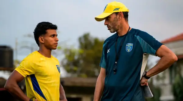 Entrenador habla con jugador joven en la liga india futbol.