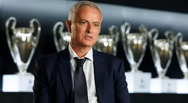 José Mourinho, el legendario **entrenador Madrid**, posa con trofeos de la Champions League.