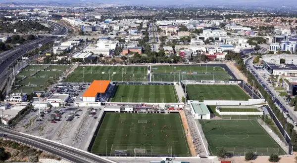 Vista aérea de la ciudad deportiva Valencia, con múltiples campos de fútbol verdes y edificios.