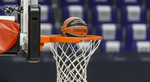 Balón de baloncesto a punto de entrar en la canasta. El juego tiene dos partes principales: ataque y defensa.