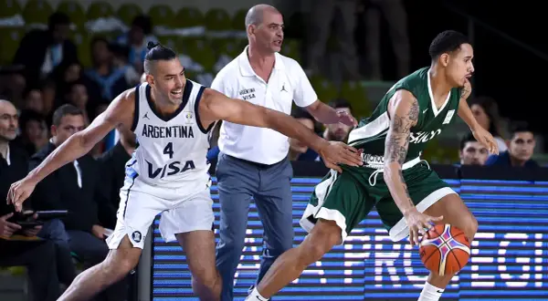 Jugadores de baloncesto argentinos en acción. El número 4 de Argentina intenta robar el balón a un oponente.
