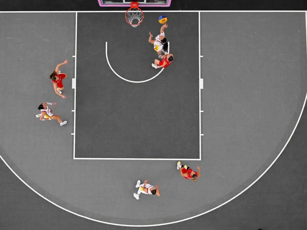Jugadoras en acción durante un partido de baloncesto 3×3. Una lanza al aro, otra defiende.