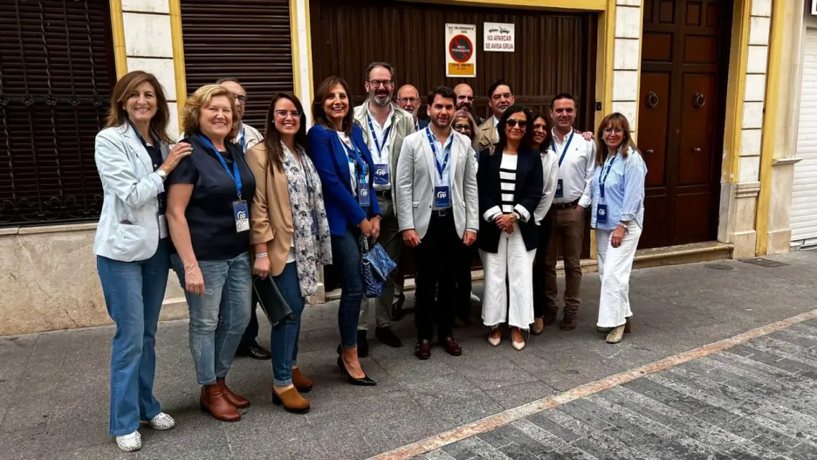 Grupo de personas sonriendo frente a un edificio. cf almaguer.